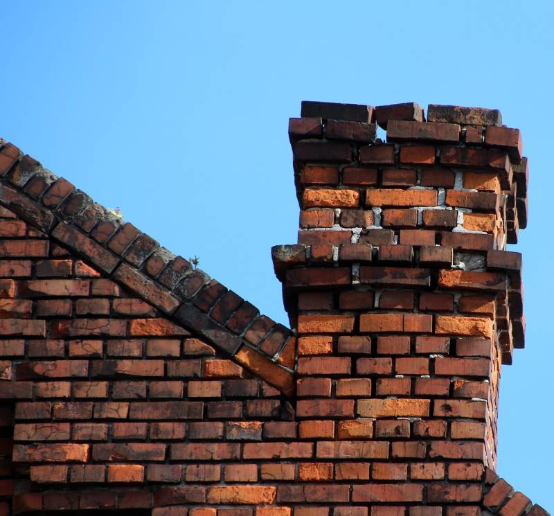 Damaged chimney on an Crowley home showing cracks and missing mortar